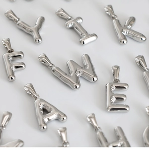 Detailed view of silver bubble initial pendants with high-polish 3D balloon metal finish