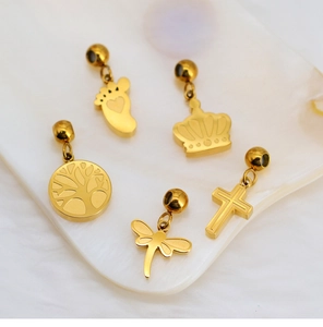 Detailed close-up of gold DIY charms featuring crown, dragonfly, and tree of life on tray