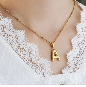Detail of 3D bubble letter A pendant in 18K gold plated steel on a fine bead chain