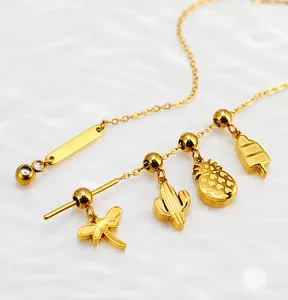 Close-up of gold stainless steel necklace with dragonfly, cactus, and pineapple charms