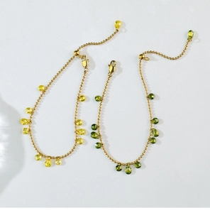 Detail of beaded gold chain with vibrant pear-shaped yellow and green crystal pendants