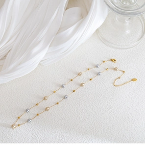 Nahaufnahme der Perlenkette in Gold mit verstellbarem Verschluss und Logo-Anhänger