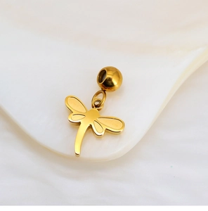 Detailed view of a golden dragonfly charm with a large hole bead on a shell tray