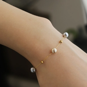 Elegantes goldenes Titanarmband mit grauen und Champagner-Perlen für Damen
