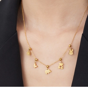 Close-up of golden necklace with animal charms worn by a model in a black suit