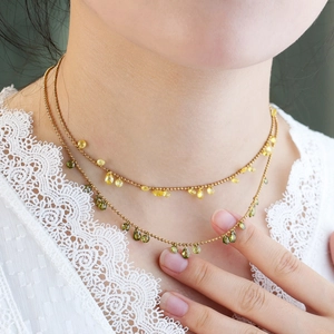 Gold-plated layered necklace with olive green and yellow teardrop gems on beaded chain