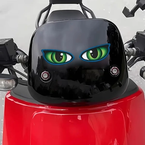Paire d'autocollants yeux de chat verts sur le pare-brise d'une moto rouge