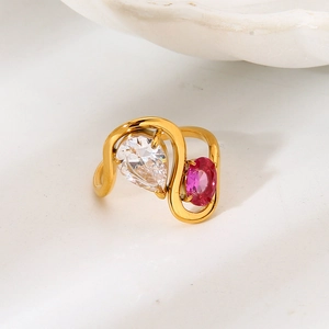 Anillo de oro ondulado con circón de pera y piedra preciosa magenta sobre fondo blanco