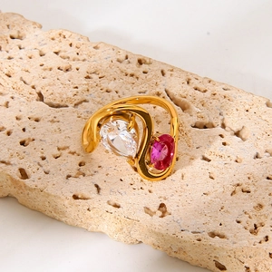 Anillo de acero dorado con piedra fucsia ovalada y circonitas en forma de pera