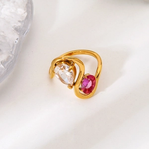 Detalle de anillo de acero dorado 18K con circonita blanca de pera y piedra rosa oval