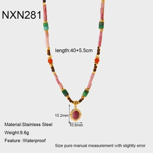 Détail d'un collier de perles colorées avec pendentif ovale rouge et acier doré