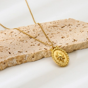 Detalle del colgante ovalado dorado con relieve de estrella del norte y textura de cadena