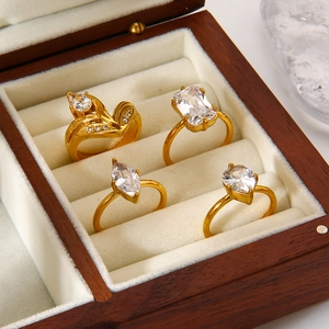 Set of four 18K gold plated stainless steel rings with geometric zircon stones in a box
