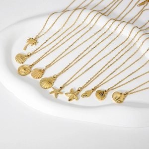 Macro display of golden sea shell and starfish pendants on fine stainless steel chains