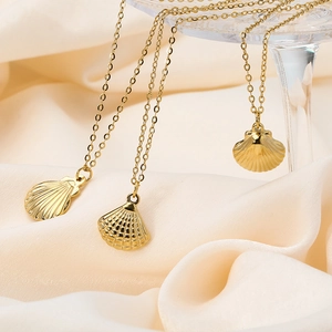 Detailed macro view of three golden seashell pendants on thin O-shaped titanium steel chains