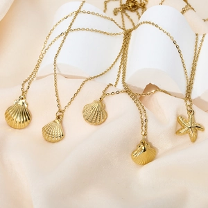 Golden ocean series shell and starfish necklaces in titanium steel on silk fabric display