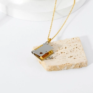 Detail of a book-shaped locket pendant with hollow heart on a natural stone tray