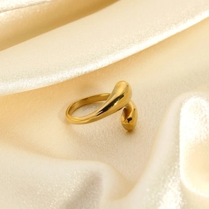 Gepolijste 18k vergulde waterdruppel ring op elegante champagne zijden achtergrond