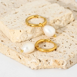 Dettaglio di orecchini a cerchio placcati oro 18K con perla naturale su pietra