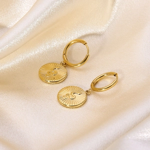 Detailed macro of gold plated stainless steel hoop earring with snake coin pendant