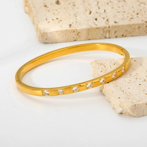 Bracciale rigido in acciaio dorato con sette zirconi cubici su base in pietra moderna