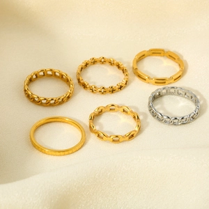 Dettaglio macro di anelli geometrici e a catena incrociata placcati in oro 18K su seta
