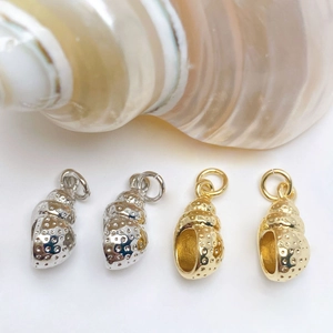 Detailed view of spiral shell pendants with micro-pave texture in gold and silver finish
