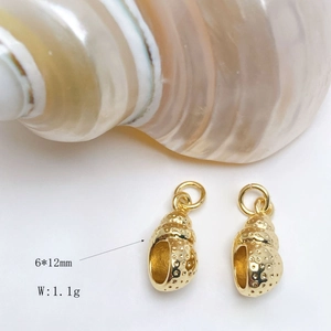 Macro detail of gold conch charms with textured surface, 6x12mm size and 1.1g weight