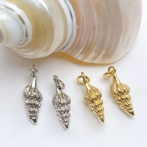 Detailed close-up of shell charms in gold and silver finish with realistic spiral textures