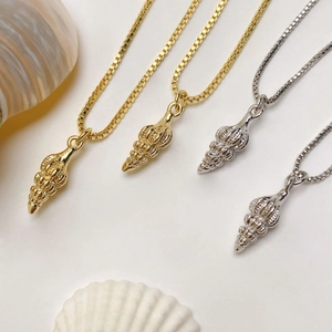 Detailed view of gold and silver conch shell pendants on delicate box chains with shells