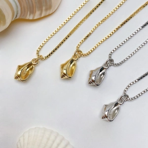 Detailed shot of conch-shaped pendants in gold and silver finish with box chains