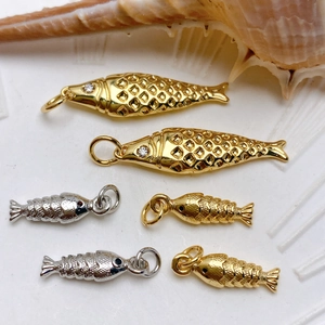 Detailed view of small fish pendants with micro-set zircon and fine scale textures