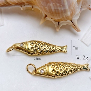 Detailed macro view of 25mm gold fish pendant with zircon eye and hollow diamond pattern
