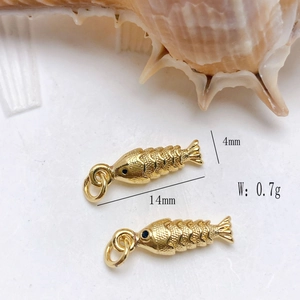 Detail view of 14x4mm golden fish pendants with scales on white conch shell