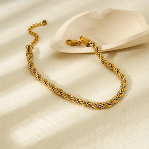 Detailed macro view of two-tone braided twist chain bracelet with lobster clasp closure