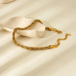 Detail of twisted gold and silver rope bracelet with lobster clasp and extension chain