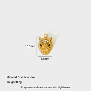 Macro detail of a 10.5mm gold leopard head pendant in stainless steel with green gemstone eyes