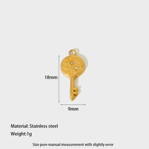 Detail of a 1g gold-plated stainless steel key charm with sun and star engravings