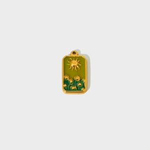 Detail van een rechthoekige gouden hanger met zon en madeliefje in groen emaille