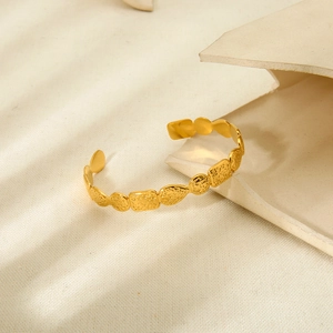 Hammered geometric 18k gold plated stainless steel open bangle on white props