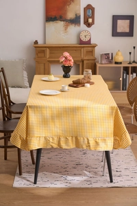 Détail d'une nappe à carreaux jaunes et blancs avec bords à volants élégants