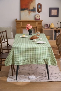 Détail de nappe à carreaux vichy vert et blanc avec bordure à volants pour table à manger
