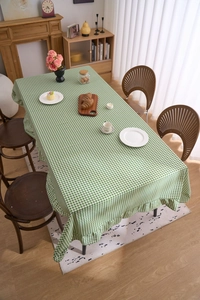 Détail de nappe à carreaux verts avec bord à volants montrant texture et drapé