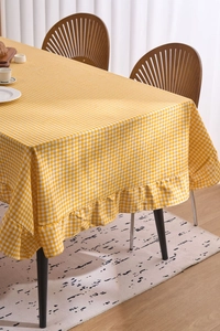 Détail de la nappe à carreaux jaunes avec un design élégant à bordure volantée