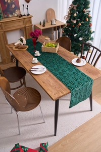 Detail of dark green velvet table runner with gold embroidered Christmas tree patterns