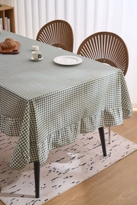 Vue détaillée de la nappe à carreaux verts et blancs avec bordure décorative à volants