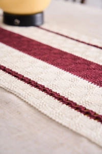 Detailed macro shot of red and white striped knit table runner with cable knit texture