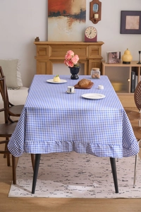 Détail de la nappe à carreaux bleus et blancs avec une élégante bordure à volants
