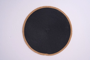 Detailed top view of a modern round woven placemat with black core and natural tan border