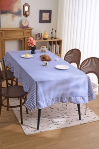 Gros plan d'une nappe à carreaux bleus et blancs avec des bords à volants décoratifs